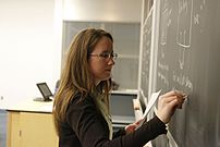 A teacher writing on a blackboard.